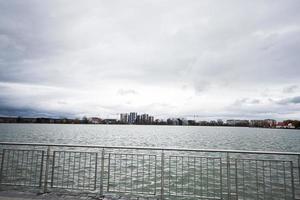 Lake promenade with glass building multistorey residental house on background. photo