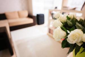 White roses flowers bouquet in green pot at home. photo