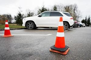 Traffic orange cones standing on a street along the parking cars. photo