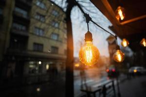 Light bulbs garland in rain city street. photo