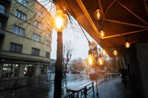 ligero bombillas guirnalda en lluvia ciudad calle. foto