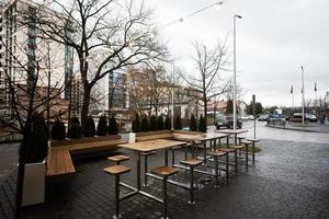 vacío ciudad café terraza con mesas y sillas, guirnalda de ligero bombillas foto