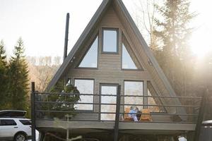 Baby girl sit on terrace off grid tiny house in the mountains. photo