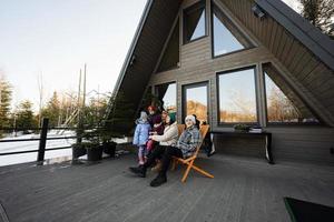 Mother with four children sit on terrace off grid tiny house in the mountains. photo