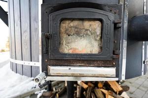 Big wooden barrel hot tub and steel oven for heating water. photo