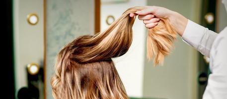 Hairdresser holds strand of hair photo