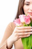 Young woman holds pink tulips photo