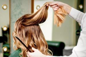 Hairdresser holds strand of hair photo