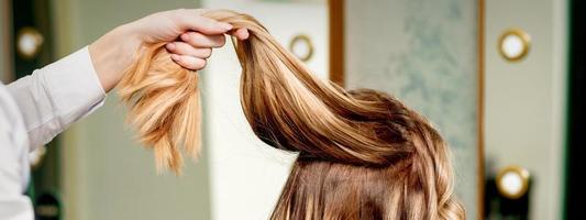 Hairdresser holds strand of hair photo