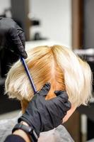 Hairdresser combing female short hair photo