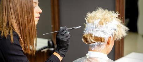 Female hairdresser dyeing short hair photo