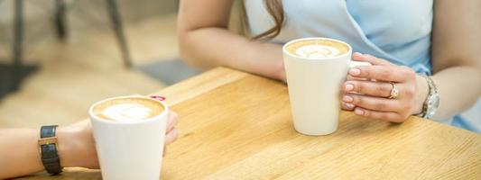 Female hands with cups of coffee photo