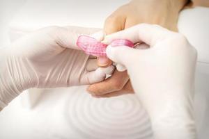 Manicurist brushing dust from nails photo