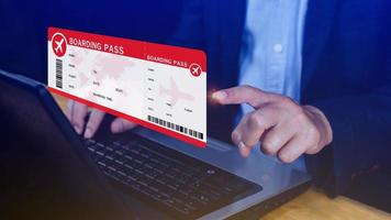 Hand holding boarding pass tickets air travel concept, Choosing checking electronic flight ticket on laptop. photo