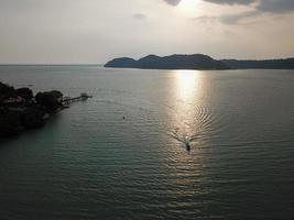 A boat move at sea with background Batu Kawan photo