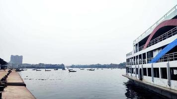 Small boats are running in the river. A front view from the bank of the river.A large vessel standing on the bank of the river. video