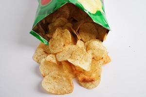 Potato chips in open bag, delicious BBQ seasoning spicy for crips, thin slice deep fried snack fast food in open bag. photo