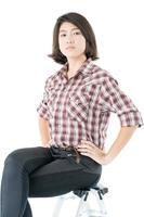 Young woman in a plaid shirt posing in studio on white photo