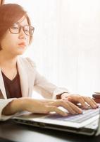 Woman teenage working on laptop in home office photo