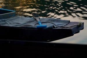 Paddle placed on the prow of a Thai-style gondola that floats on the surface of the water with the twilight atmosphere. soft and selective focus. photo