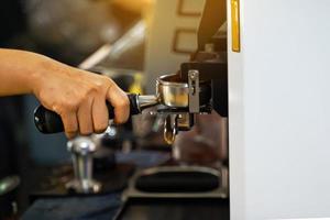 The barista makes coffee with the coffee machine according to the orders of customers who come to use the service at the shop. Soft and selective focus. photo