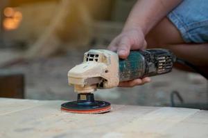 Carpenters use a sander to sand the surface of the wood to smooth the woodwork before painting. Soft and selective focus. photo