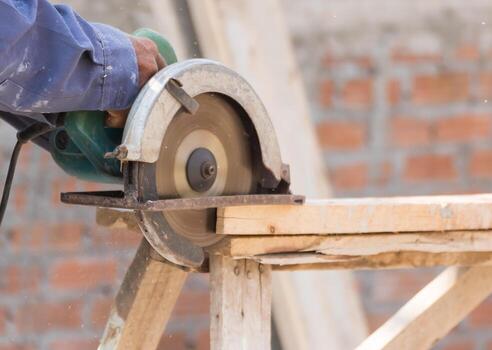 Carpenter using circular saw in loggers photo