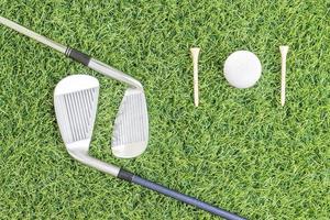 Golf club and golf ball on green grass photo