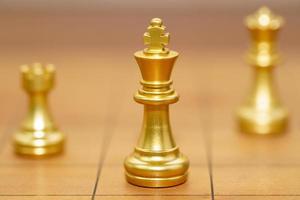 Gold king chess piece stand on wood chessboard photo