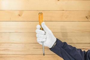 Hand in glove holding screwdriver photo