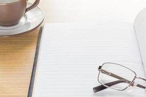 Eyeglasses and Notepad with blank page photo