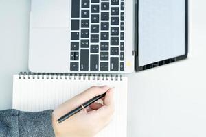 Woman working at home office using laptop searching web, browsing information photo