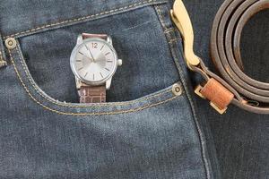 reloj de pulsera y cinturón de cuero en jeans foto