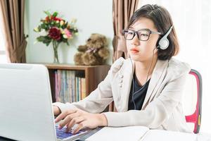 Teenage girl working on laptop in home office photo