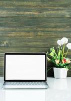 Laptop mockup with wood background on the work table photo