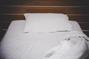 Messy white bed and pillow photo