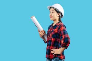 Young female engineer wearing white safety helmet with Blueprints photo