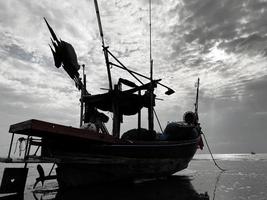 pescar barcos durante puesta de sol cielo a playa paisaje, pescar barcos durante un amanecer o atardecer, reluciente de el Dom en el nubes, las cielo y nubes tener el poder a inspirar sentimientos de temor o preguntarse foto