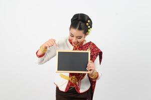 retrato de hermosa tailandés mujer en tradicional ropa posando con pizarra foto