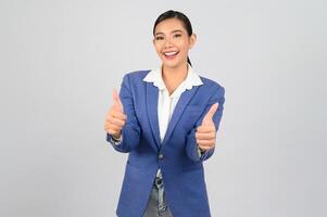 Young beautiful woman in formal clothing for officer with thumb up posture photo