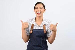 retrato, mujer joven asiática, en, camarera, uniforme, con, pulgar up, postura foto