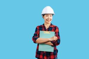 Young asian engineer female use pen to check list on clipboard posture photo