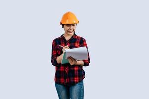 Young female engineer wearing Yellow helmet and clipboard photo