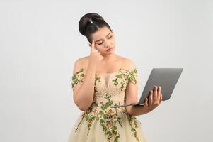 Young asian beautiful bride pose with laptop computer in hand photo