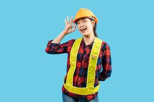Young female engineer in helmet stand with OK sign posture photo