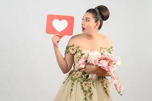 Asian beautiful bride smiling and posing with heart sign on white background photo