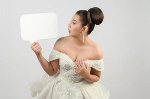 Young asian beautiful bride pose with mockup banner in hand photo