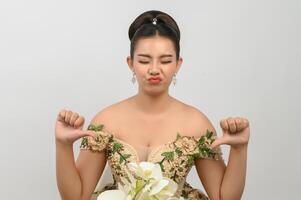 Young asian beautiful bride with orchid bouquet on white background photo