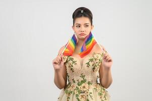 Young asian beautiful bride with rainbow flag on white background photo