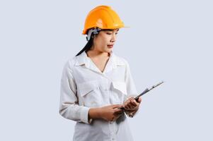 Young female engineer wearing Yellow helmet and clipboard photo